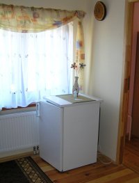 A small fridge on the floor next to the rooms.
